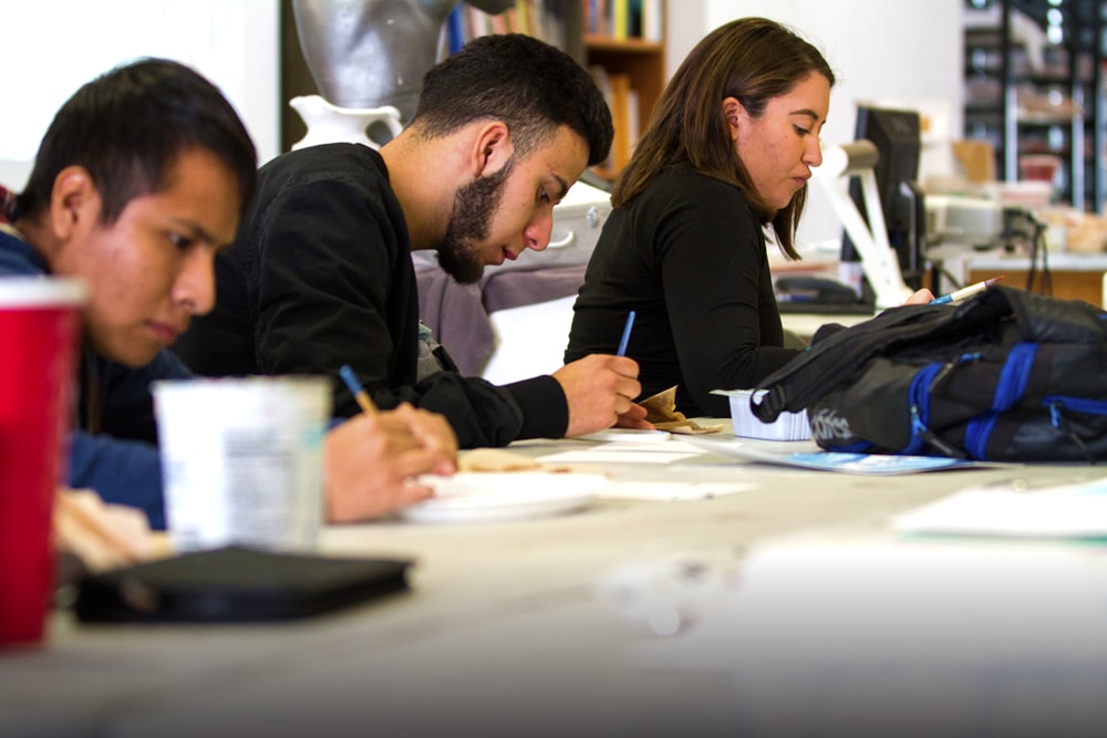 Three students concentrating on school work