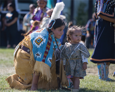 Native American teen and child dressed in native clothes