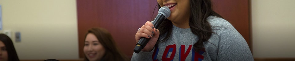 Student presenting in class with microphone in hand