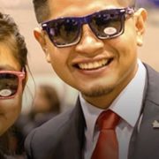 Students dressed nicely at Enactus event smiling at camera with sunglasses on