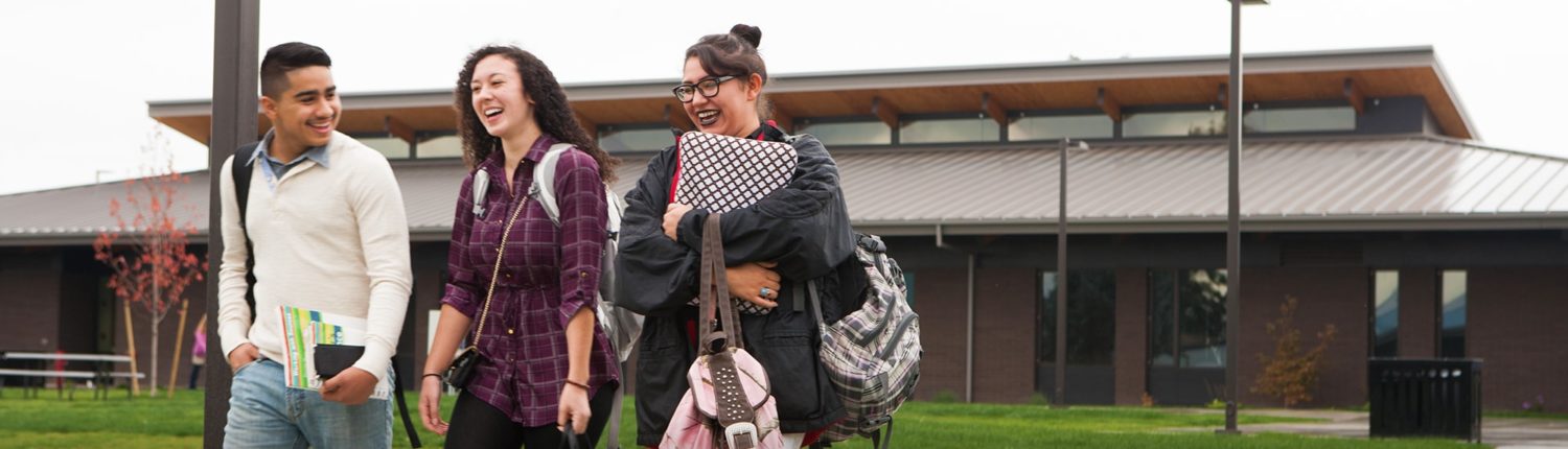 three students walking laughing with each other on heritage campus