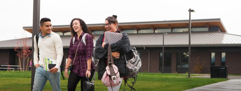 three students walking laughing with each other on heritage campus